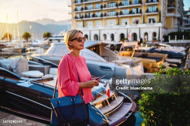 mujer madura usando tableta digital al aire libre - hotel de lujo fotografías e imágenes de stock