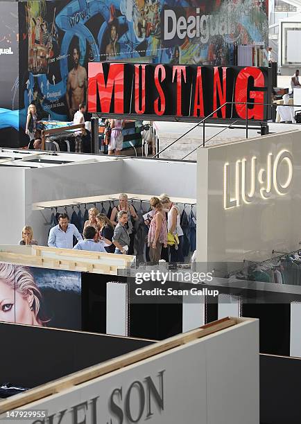 Visitos look among stand in the Denim hall at the 2012 Bread & Butter fashion trade fair at former Tempelhof Airport on July 6, 2012 in Berlin,...