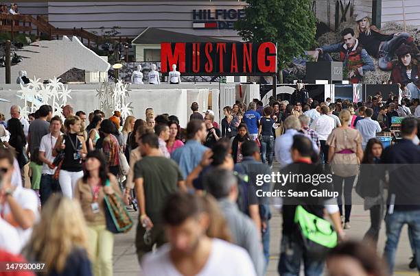 Visitors walk among stands in the Denim hall at the 2012 Bread & Butter fashion trade fair at former Tempelhof Airport on July 6, 2012 in Berlin,...