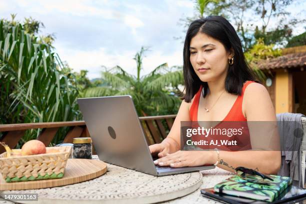 woman working with laptop sitting at table in backyard - blogging stock pictures, royalty-free photos & images