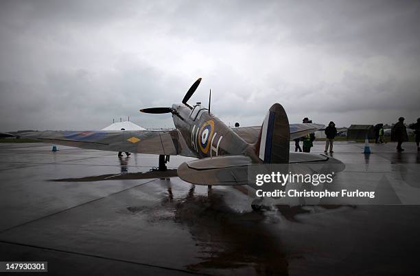 Visitors brave the inclement weather to view a replica Spitfire aircraft on display at the Royal International Air Tattoo on July 6, 2012 in...