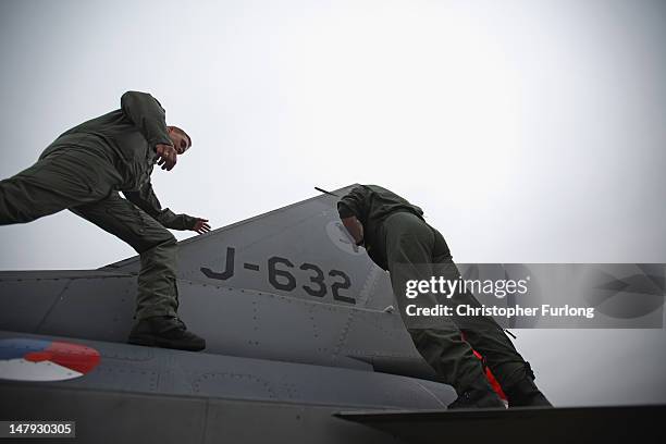 Air crew form The Royal Netherlands Air Force check over their F-16 fighter jet at the Royal International Air Tattoo on July 6, 2012 in Fairford,...