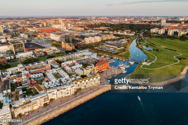 aerial view of a neighborhood by the sea with an entrance to a marina. - malmo stock pictures, royalty-free photos & images