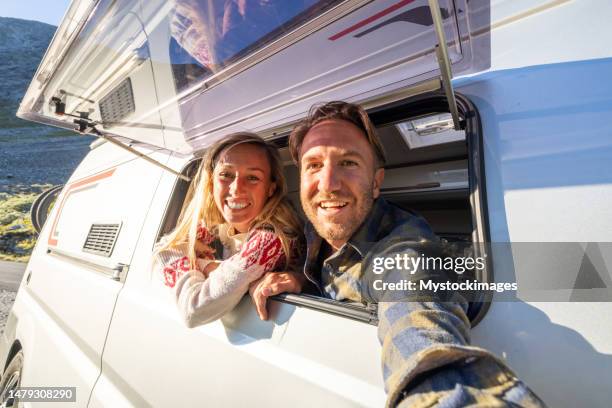 couple in a van taking a selfie, van life concept - zelfportret stockfoto's en -beelden