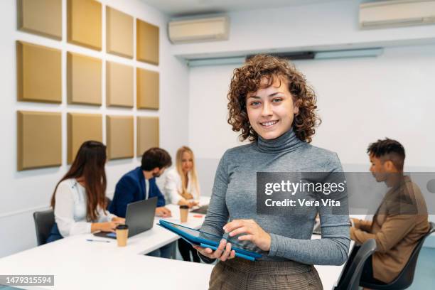 portrait of young brunette temporal worker woman smiling at workplace - southern european descent stock pictures, royalty-free photos & images