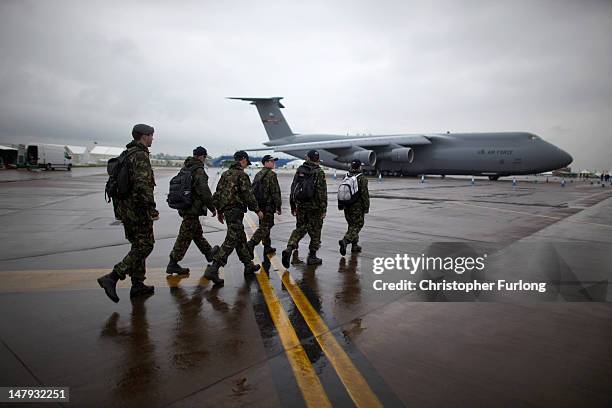 Royal Air Force cadets walk past a United States Galaxy as they arrive at RAF Fairford to take up marshalling duties during the Royal International...