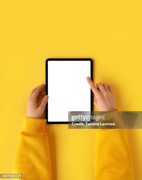 female hand in yellow hoodie using digital table with white screen. minimalistic composition with copy space. goals setting, finance, economy, world crisis, analysis concept - tableta gráfica fotografías e imágenes de stock