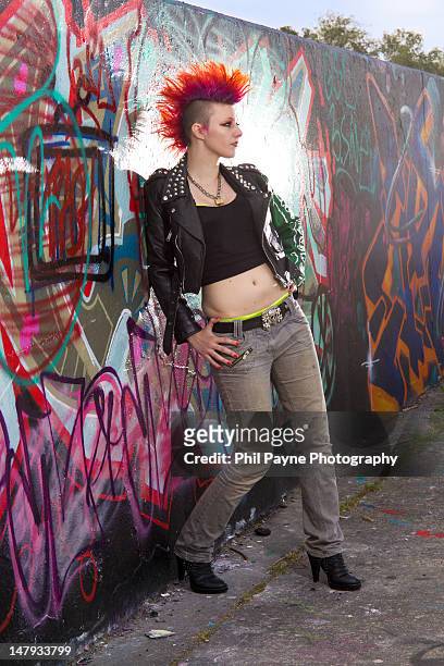 young punk woman leaning on wall - mohawk stock pictures, royalty-free photos & images