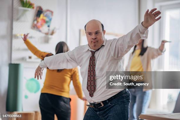 people with down syndrome and cerebral palsy dancing and having fun at a party - cerebral palsy stock pictures, royalty-free photos & images