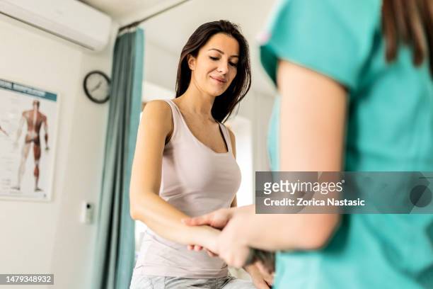 smiling female patient having problem with wrist - pressure point bildbanksfoton och bilder