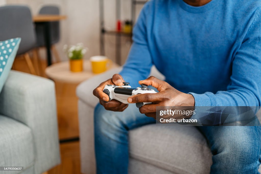 Joven jugando videojuegos en casa