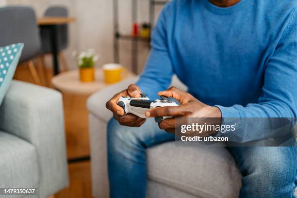 giovane che gioca ai videogiochi a casa - controller di videogame foto e immagini stock