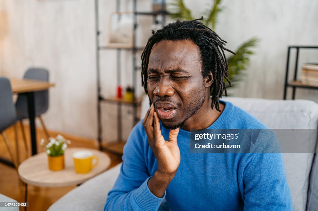 Joven con dolor de muelas en casa