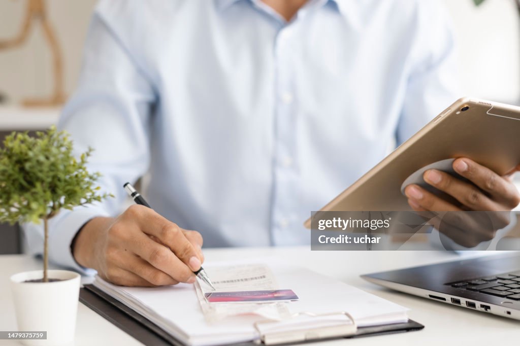 Close-up Businessman pays bills with digital tablet