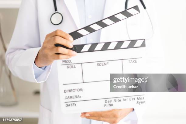 close-up doctor holding clapperboard - film slate stock pictures, royalty-free photos & images