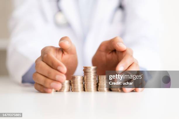 the doctor protects the savings - bonus pay stock pictures, royalty-free photos & images