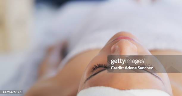 visage, spa et détente avec une femme sur un lit, allongée pour le bien-être, le soin de luxe ou la paix lors d’une escapade d’un week-end. massage, santé ou beauté et jeune femme avec extensions de cils dans un salon - anthropomorphic face photos et images de collection