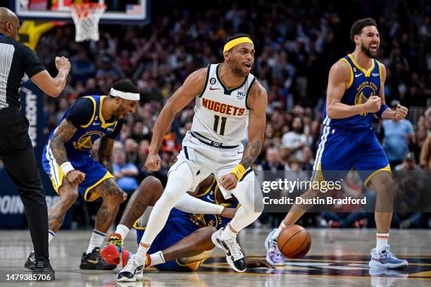 Bruce Brown of the Denver Nuggets and Klay Thompson and Gary Payton II of the Golden State Warriors react as referee Tre Maddox calls for a jump ball...