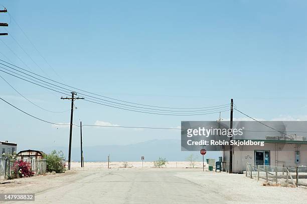 road with a stop sign - localidad pequeña fotografías e imágenes de stock