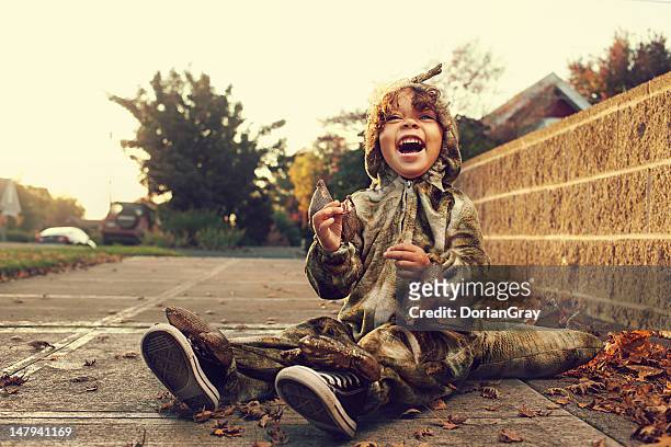 young boy in dinosaur costume during halloween - halloween 2011 stock pictures, royalty-free photos & images