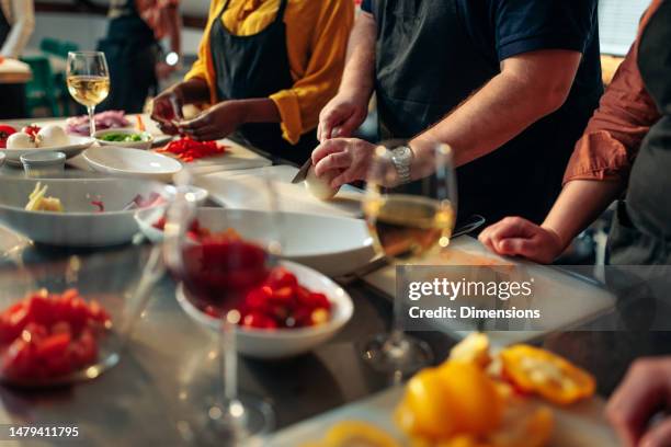 students cutting vegetables in cooking class. - cooking school stock pictures, royalty-free photos & images