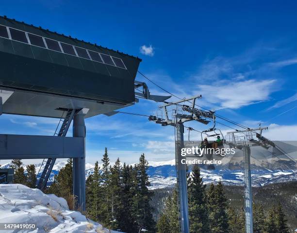 skier and snowboarder nearing the top of a ski lift, keystone ski resort colorado. - keystone stock pictures, royalty-free photos & images