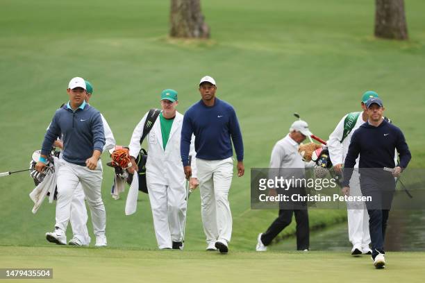 Tom Kim of South Korea, Tiger Woods of the United States and Rory McIlroy of Northern Ireland walk to the 16th green during a practice round prior to...