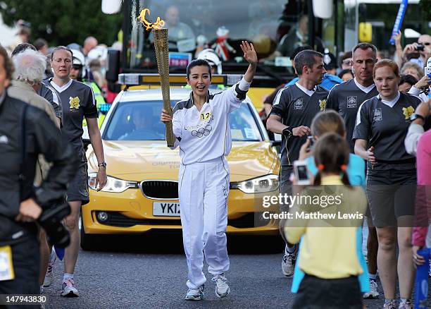 Torchbearer Li BingBing of China carries the Olympic Flame on the Torch Relay leg between Ipswich to Chelmsford on July 6, 2012 in Herongate,...