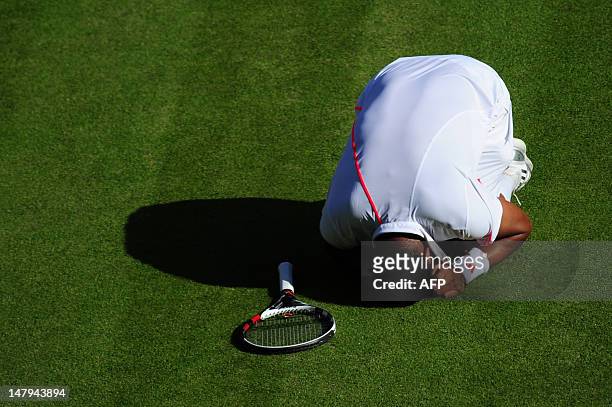 France's Jo-Wilfried Tsonga reacts after being hit in the groin by a ball during his men's singles semi-final match against Britain's Andy Murray on...