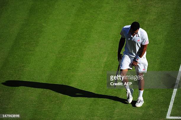 France's Jo-Wilfried Tsonga reacts after being hit in the groin by a ball during his men's singles semi-final match against Britain's Andy Murray on...