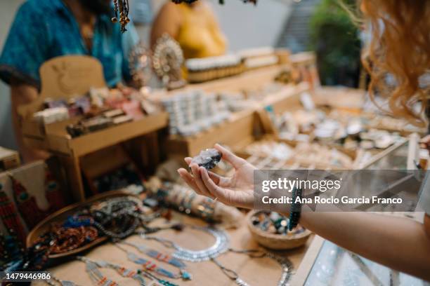 woman buying a gemstone in a street market - schmuckstein stock-fotos und bilder