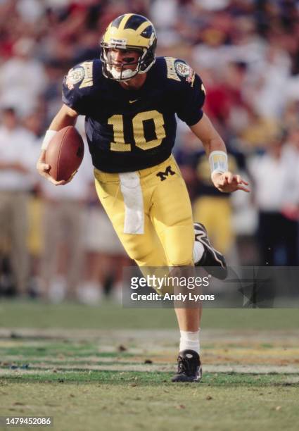 Tom Brady, Quarterback for the University of Michigan Wolverines in motion running the football downfield during the NCAA Florida Citrus Bowl college...