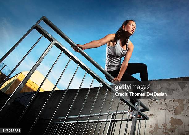 woman jumping over fence obstacles - freerunning stockfoto's en -beelden