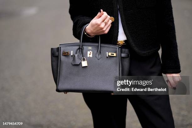 May Berthelot wears a white ribbed tank-top, a black tweed with embroidered gold buttoned tweed jacket from Celine, a black shiny leather with gold...