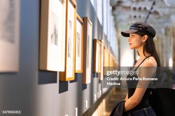 young woman appreciating works of art - 20 the exhibition stockfoto's en -beelden