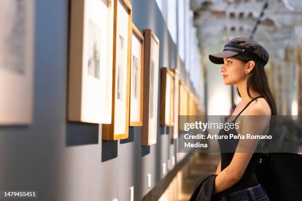 young woman appreciating works of art - gallery opening stock pictures, royalty-free photos & images