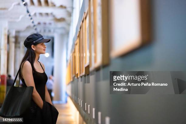 giovane donna che apprezza le opere d'arte nel museo - museum foto e immagini stock