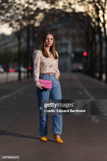 Maria Rosaria Rizzo wears a gold long chain with large cross pendant necklace, a beige with purple and pink tie and dye print pattern long sleeves /...