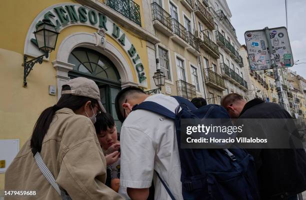 Tourists wait in line to take the Ascensor da Bica, a funicular, in Bica historical neighborhood on April 03, 2023 in Lisbon, Portugal. According to...