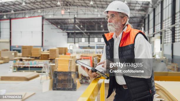 senior manager using a tablet in the factory - service management stockfoto's en -beelden