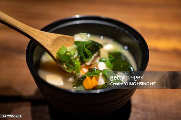 a bowl of japanese miso soup filled with kelp and ingredients. - kombu stock pictures, royalty-free photos & images