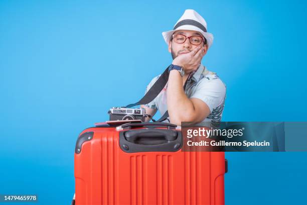 bored tourist with a camera and suitcase waiting - holiday sadness stock pictures, royalty-free photos & images