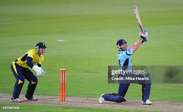 Matt Prior of Sussex smashes a six as wicketkeeper Michael Bates of Hampshire looks on during the Friends Life T20 match between Hampshire Royals and...