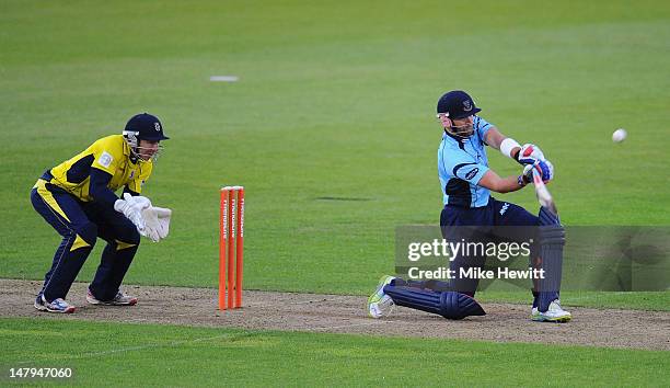 Matt Prior of Sussex smashes a six as wicketkeeper Michael Bates of Hampshire looks on during the Friends Life T20 match between Hampshire Royals and...