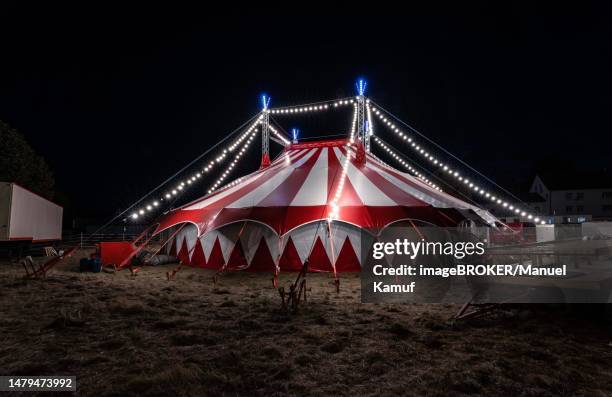 small red illuminated circus tent at night, rutesheim, germany - carpa de circo fotografías e imágenes de stock