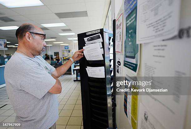 Unemployed bus driver Ricardo Rocha, who has been out of work for the past six months, picks up fliers advertising jobs at the Foothill Employment...