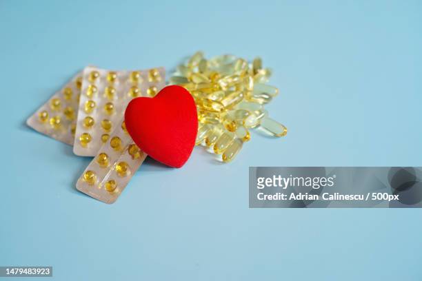omega 3 capsules with red heart fish oil in tablets health support and heart treatment the medici,romania - heart pill stockfoto's en -beelden