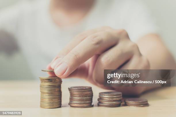 hand of male putting gold coin stack,finance and investment save money concept,romania - save money stock-fotos und bilder