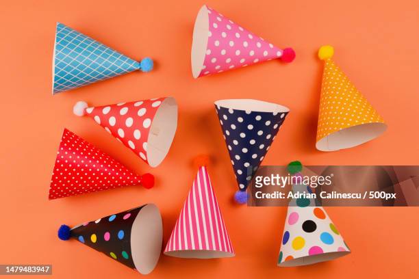 colorful birthday caps on orange background top view,romania - multi colored hat stock pictures, royalty-free photos & images
