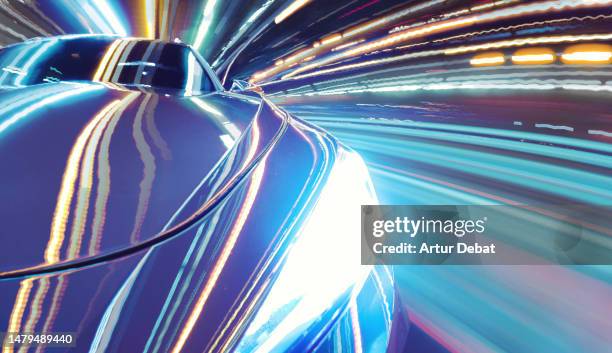 Driving a futuristic car at night with extreme urban light trails and cool vanishing point effect.